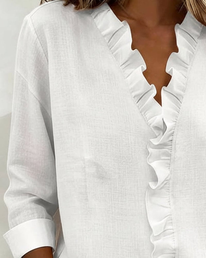 Woman wearing the Sophie ruffle blouse in black, front view
