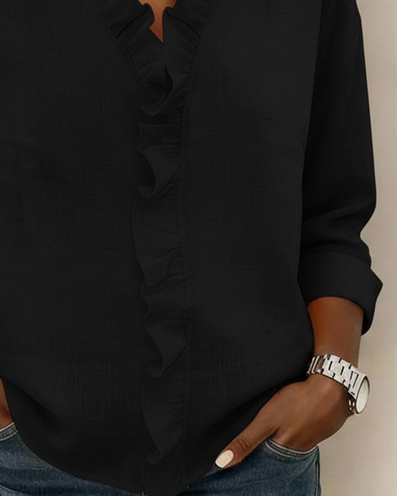 Sophie ruffle V-neck blouse in black styled with dark jeans, three-quarter view