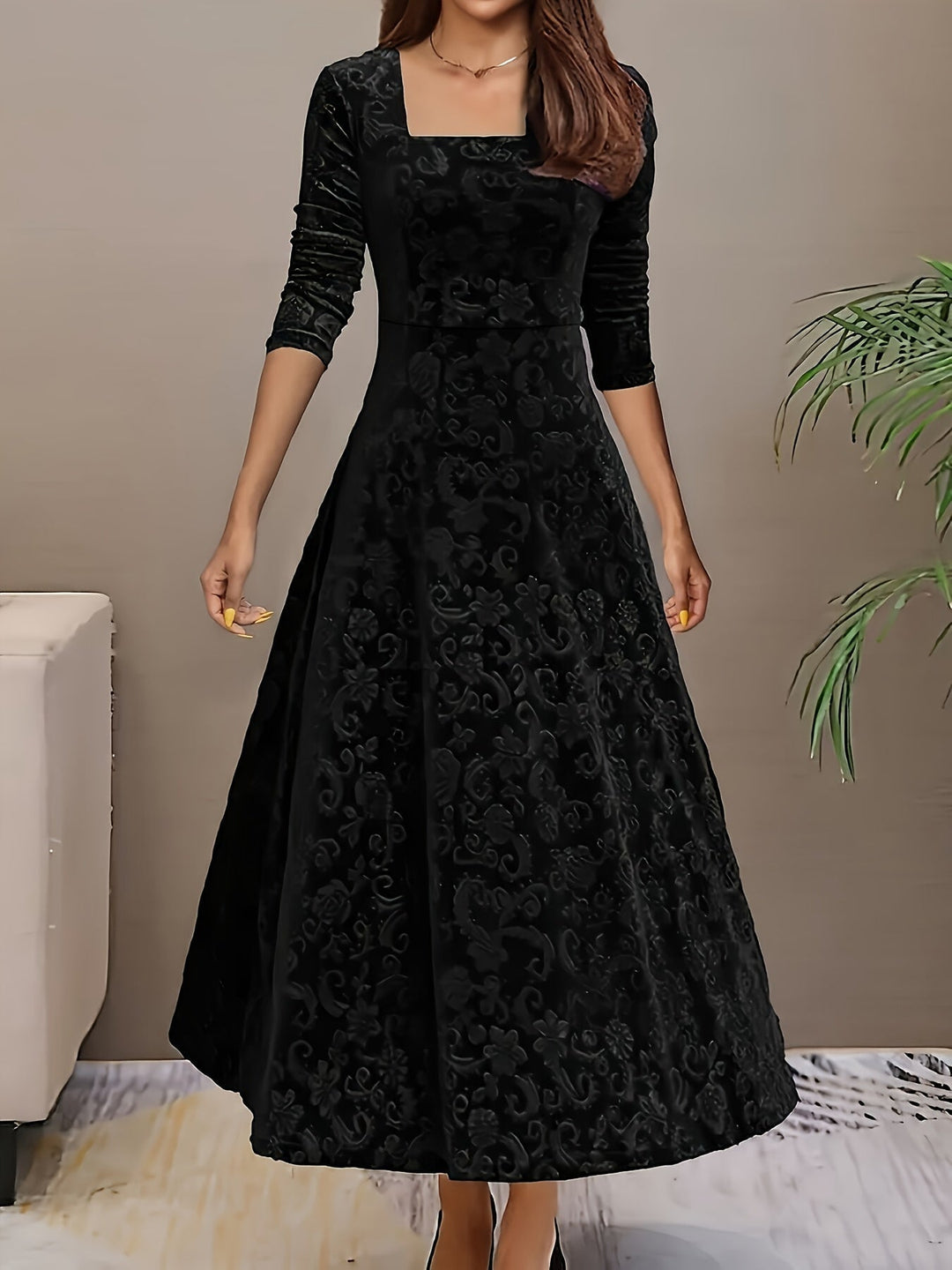 Woman wearing the Stella elegant dress in black, featuring a sculpted silhouette and plush fabric finish