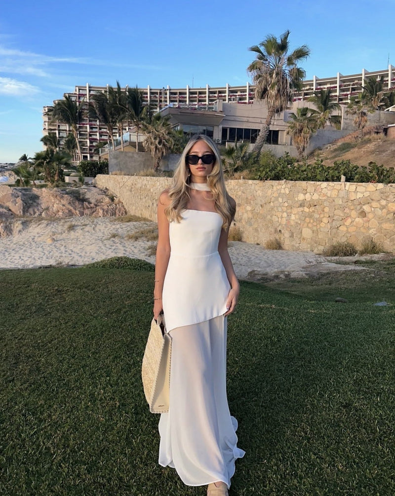 Woman wearing the Stella white strapless asymmetric maxi dress with patchwork mesh detailing and high-low hemline