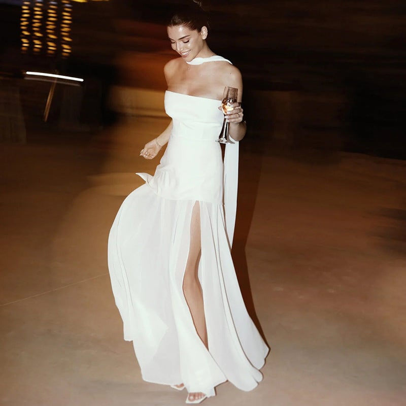 Woman wearing the Stella strapless asymmetric maxi dress in black with flowing mesh overlay