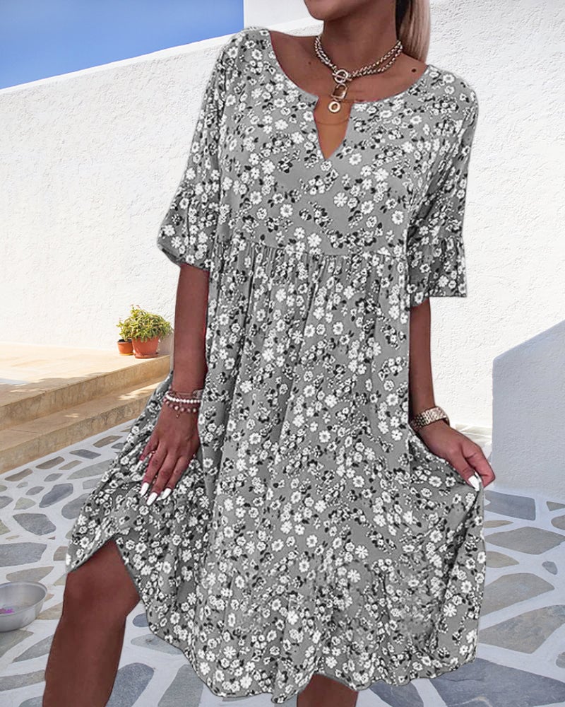 Front view of the Stella floral midi dress in gray showing the V-neckline, smocked waist detail, and tiered flowy skirt