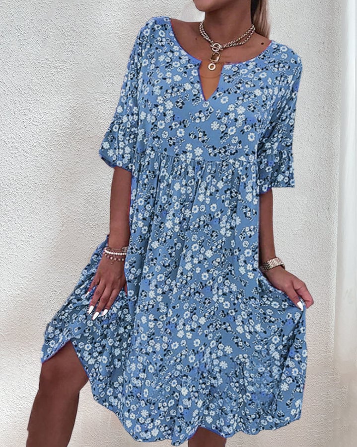 Side view of the Stella floral midi dress in blue highlighting the flutter sleeves and knee-grazing tiered hem