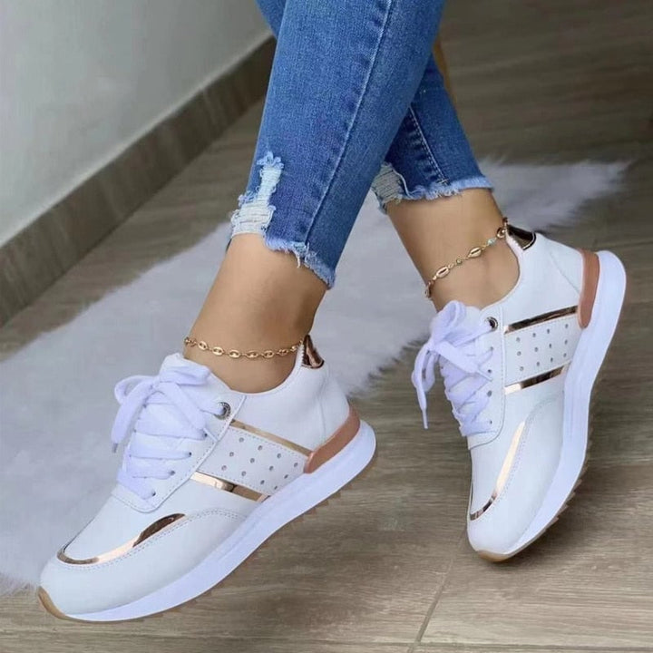 Side view of Stella sneakers showing suede-effect paneling and subtle stud accents with gold trim