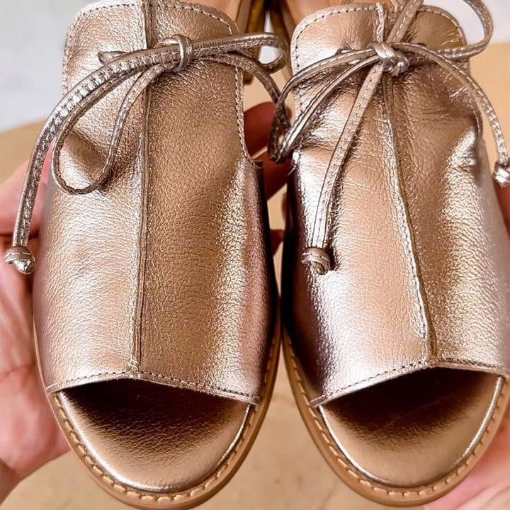 Stella metallic open-toe flat sandals in silver and gold shown side by side on a clean background