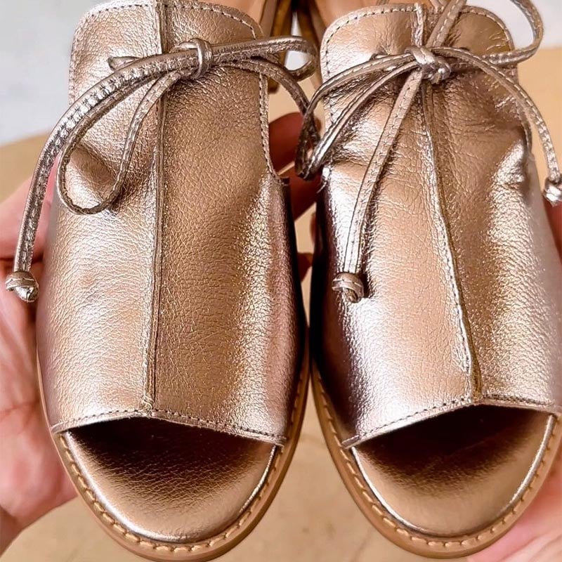 Stella metallic open-toe flat sandals in silver and gold shown side by side on a clean background
