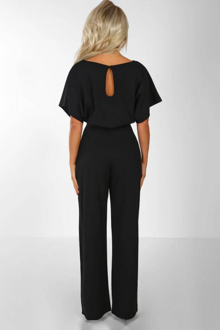 Model wearing the Stella belted jumpsuit in red with statement jewelry