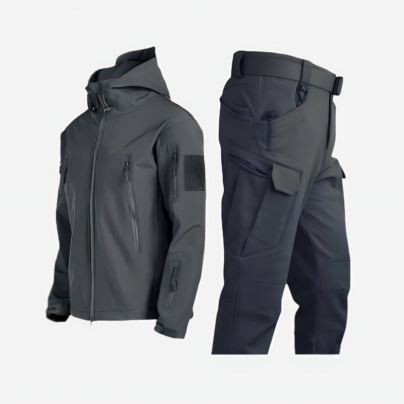 Women in green waterproof outdoor jacket and pants set standing in a forest setting