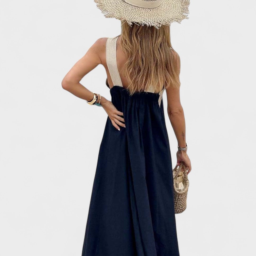 Side profile of a woman wearing a black maxi dress with a graceful flowing skirt
