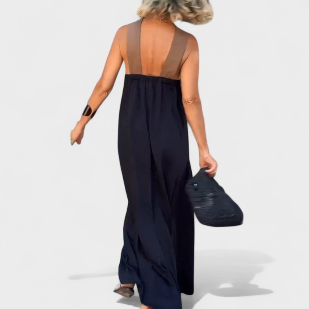 Woman in a navy blue maxi dress styled with strappy sandals for a summer occasion