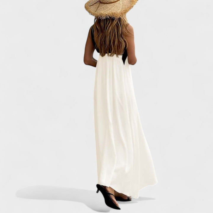 Woman in a white flowing maxi dress paired with statement earrings for an elegant look