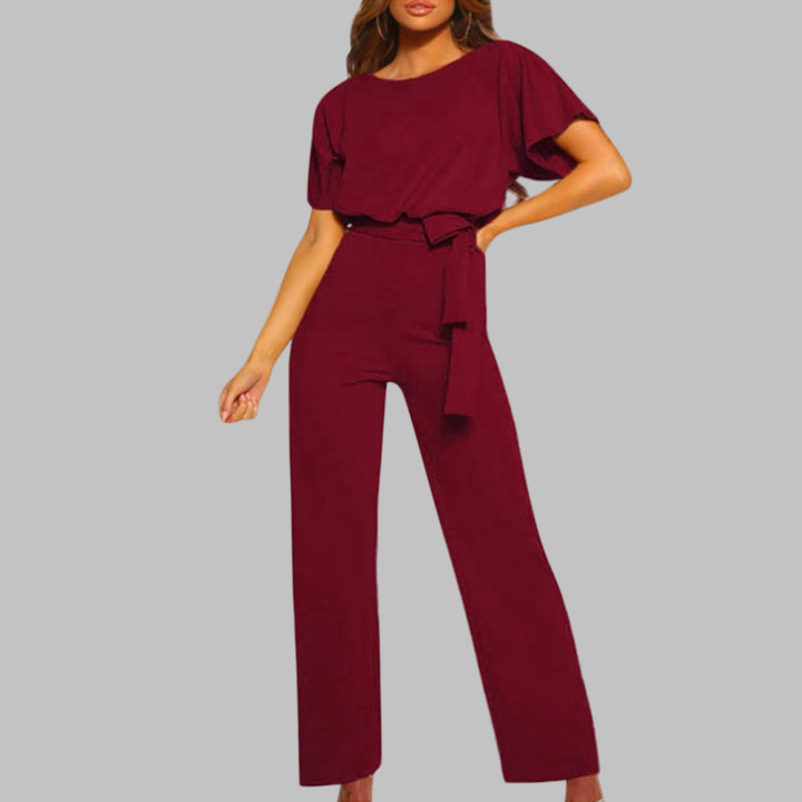 Woman wearing the Sunny belted jumpsuit in black styled with heeled sandals