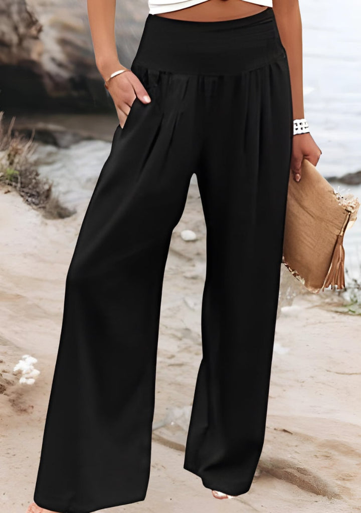 Close-up detail of the stretchy gathered waistband on lightweight wide-leg beach pants in white