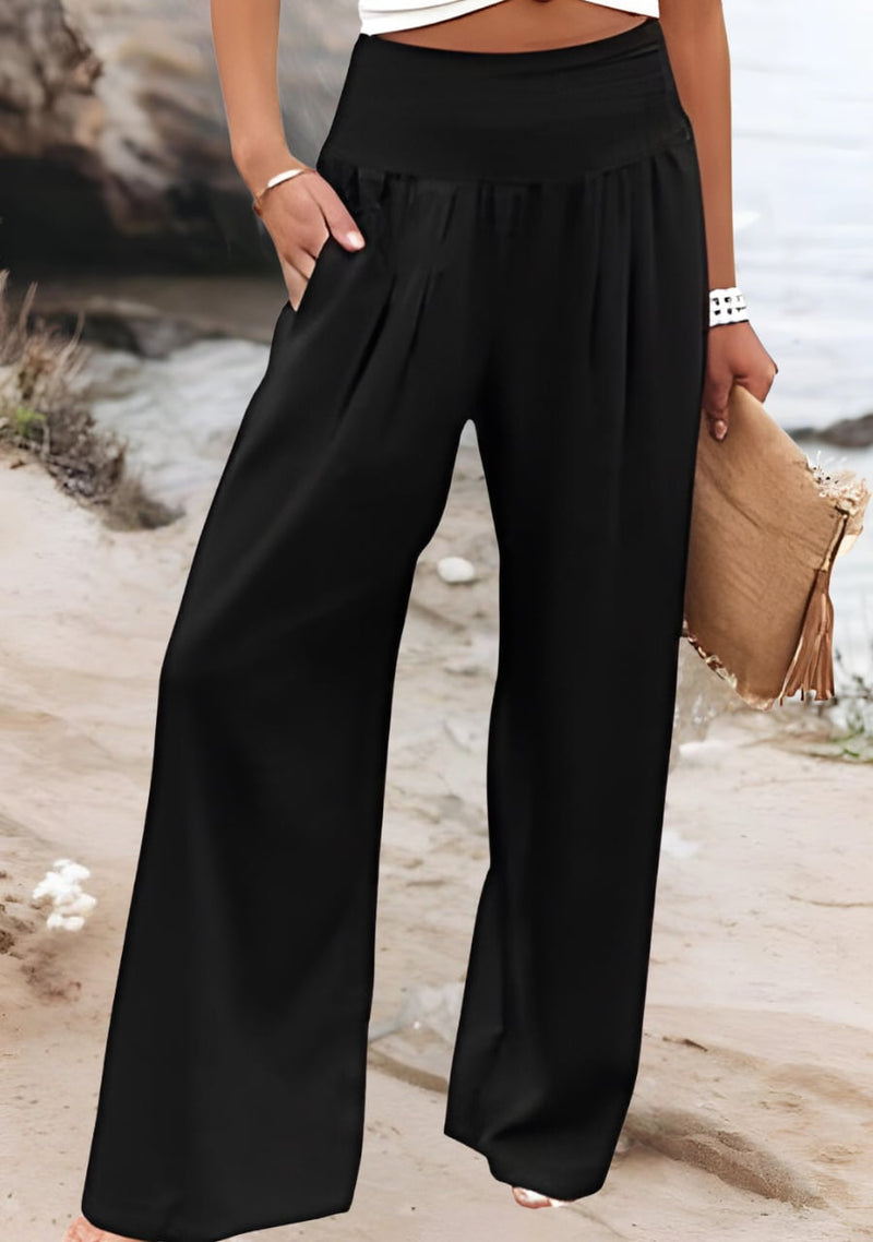 Close-up detail of the stretchy gathered waistband on lightweight wide-leg beach pants in white