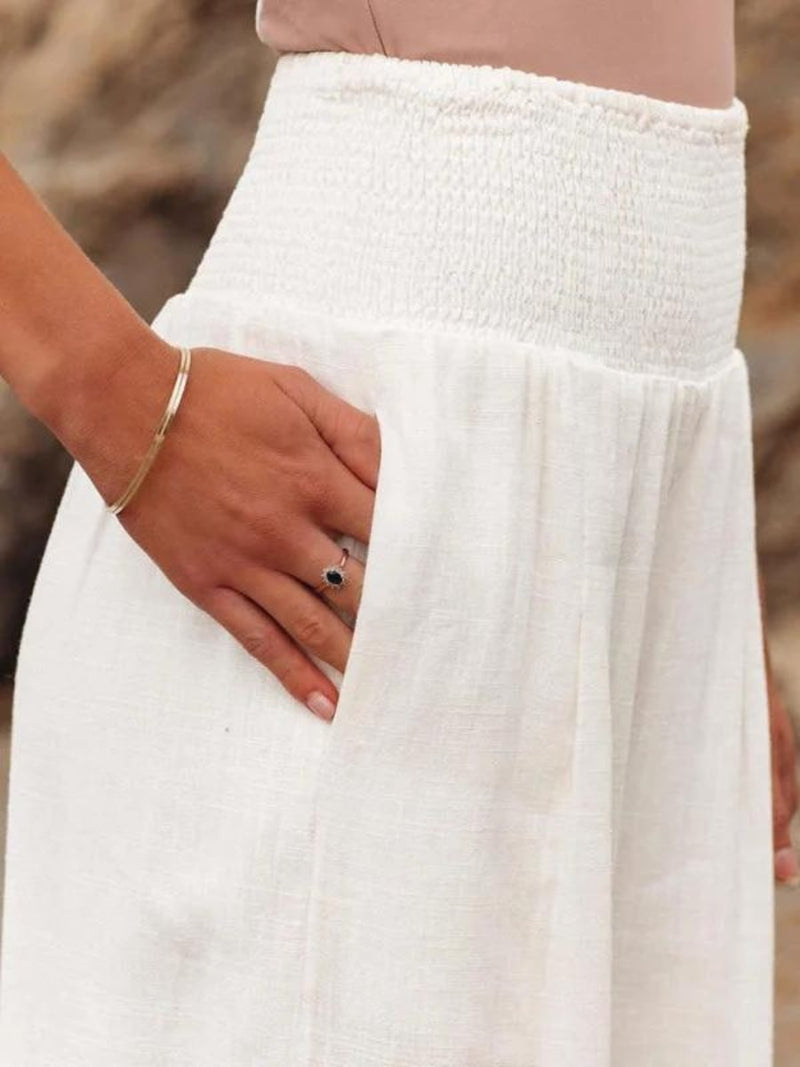 Flat lay of flowing wide-leg beach pants in three color options: beige, black, and white