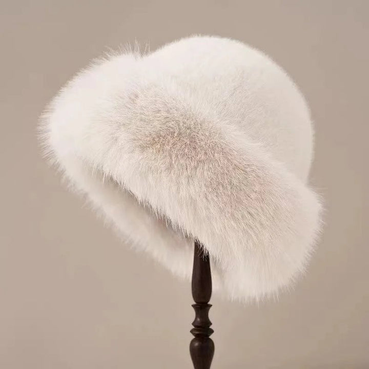 Woman wearing a plush fluffy winter hat paired with a winter coat, styled for a polished cold-weather look