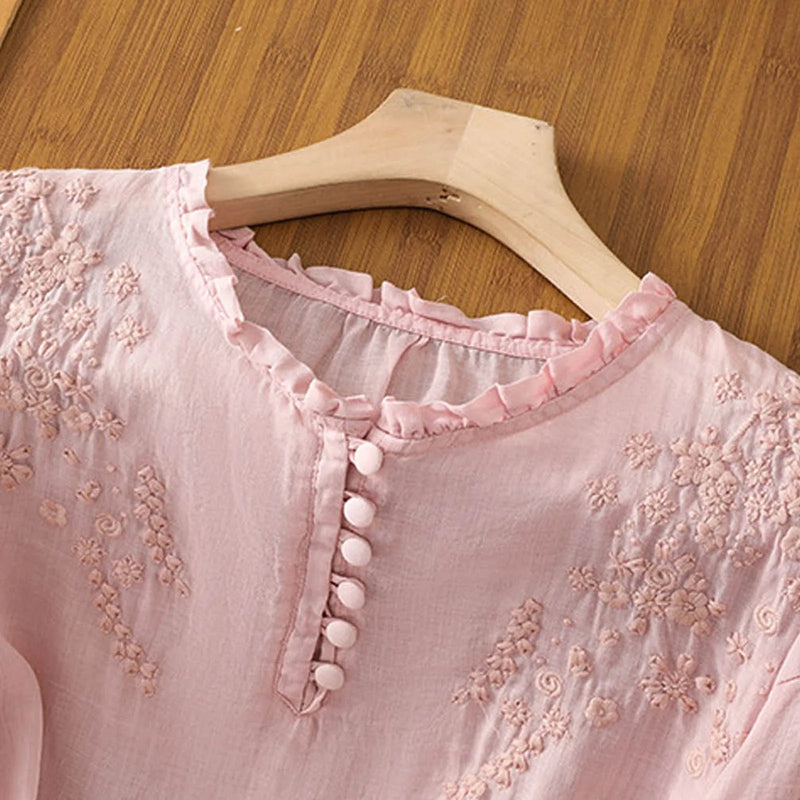 Blue floral embroidered blouse laid flat showing full button-front and neckline embroidery detail