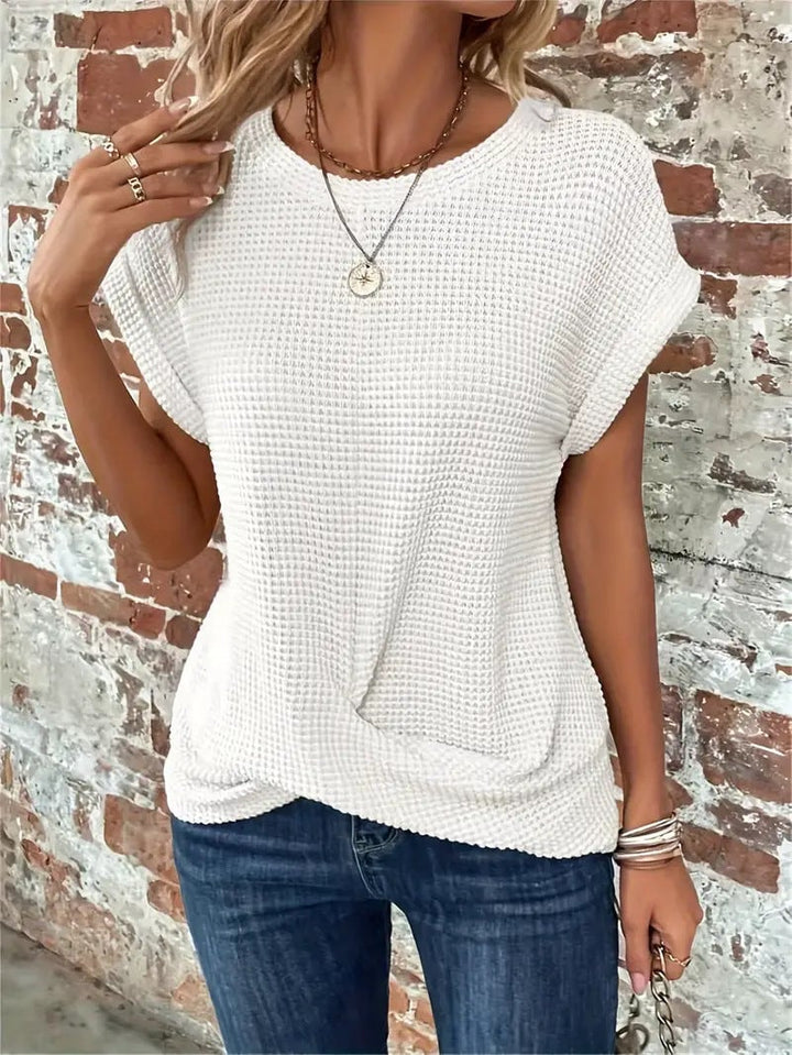 Model wearing a brown orange waffle knit casual tee with rolled sleeves and front twist detail