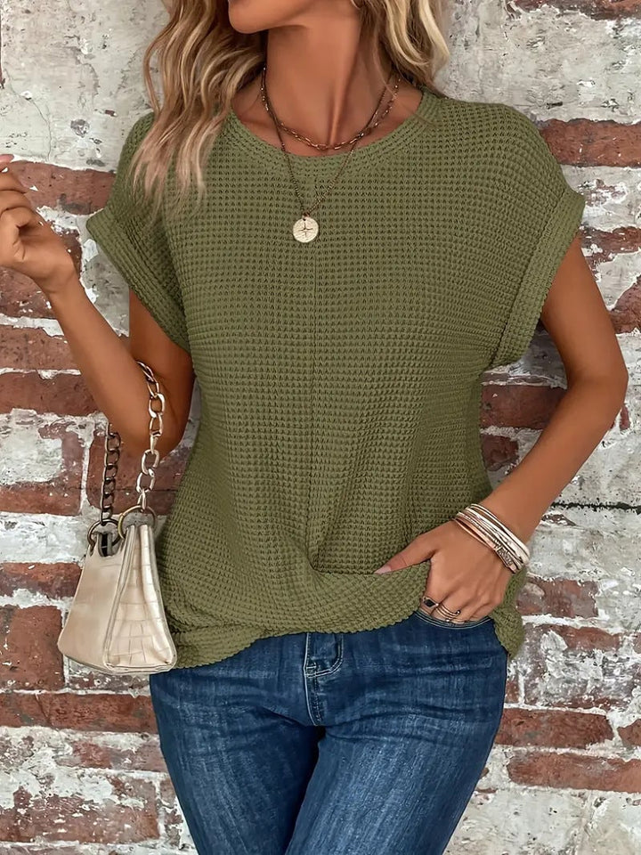 Model wearing a pinkish grey waffle knit tee with relaxed rolled sleeves