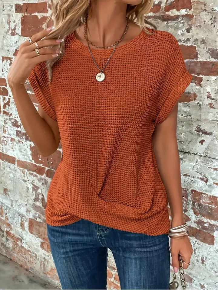 Model in black waffle knit tee styled with high-waist jeans
