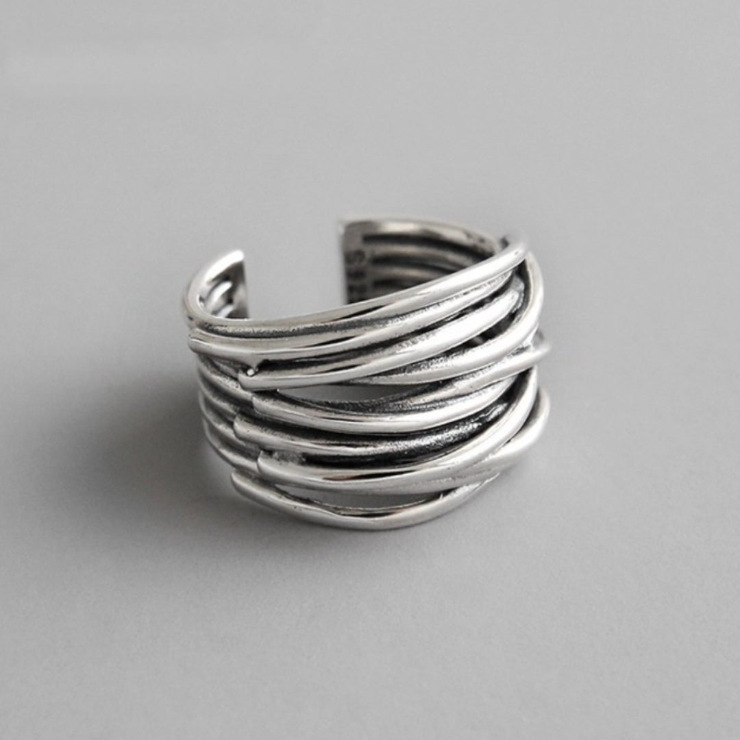 Sterling silver adjustable layered ring on a neutral background showing the delicate layered band design