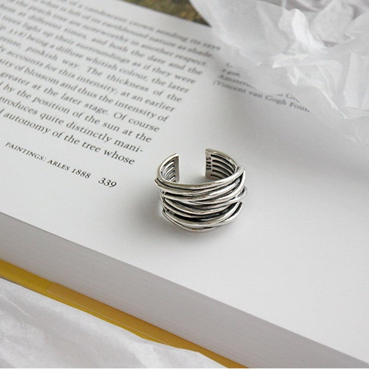 Sterling silver adjustable layered ring styled on a model's hand showing fit and scale
