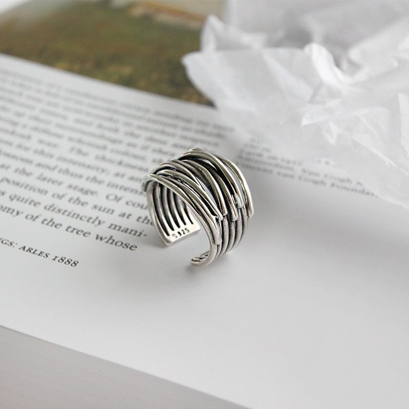 Overhead flat lay of sterling silver adjustable layered ring against a clean white surface