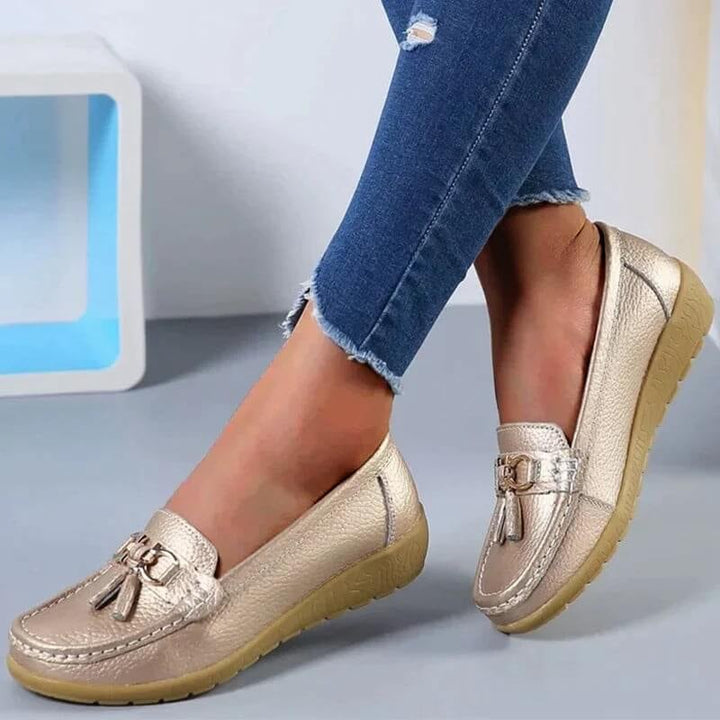 Talia slip-on loafers in orange, top-down view showing tassel hardware and stitching detail