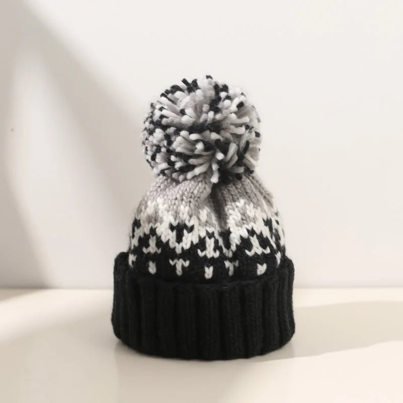 Cozy knit snowflake pom beanie in black with a fluffy pom-pom on top