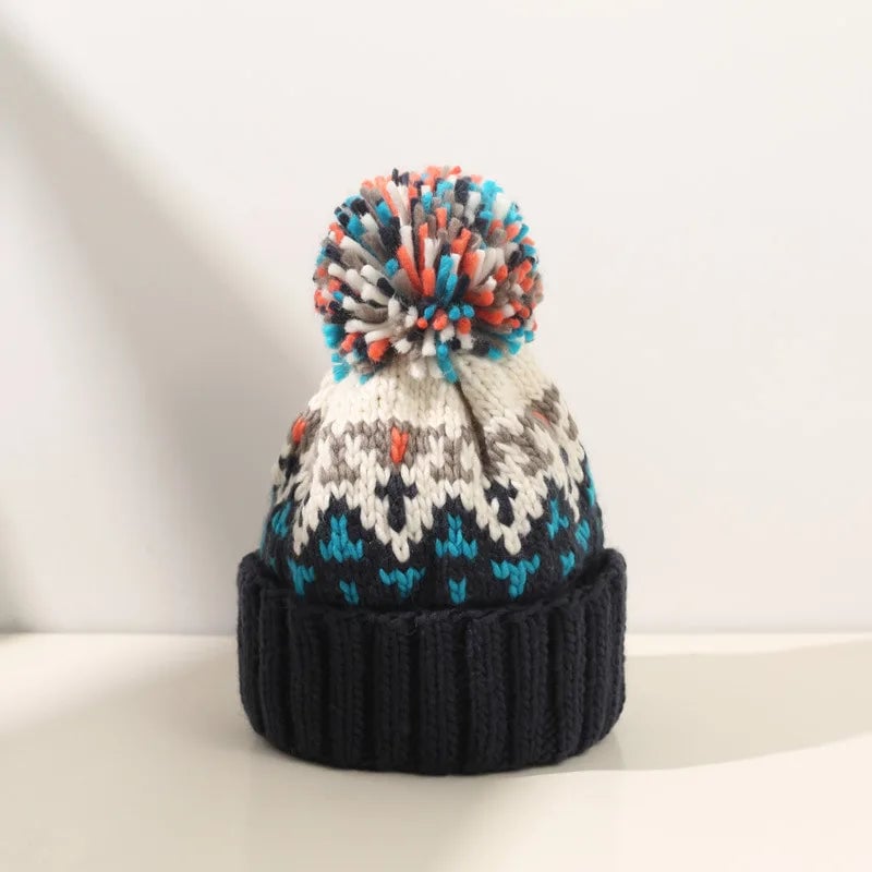 Snowflake pom beanie in orange worn as a front-facing style shot