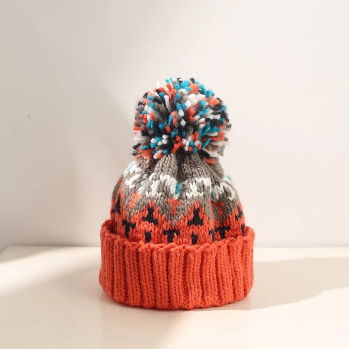Off-white snowflake pom beanie showing festive knit pattern close-up