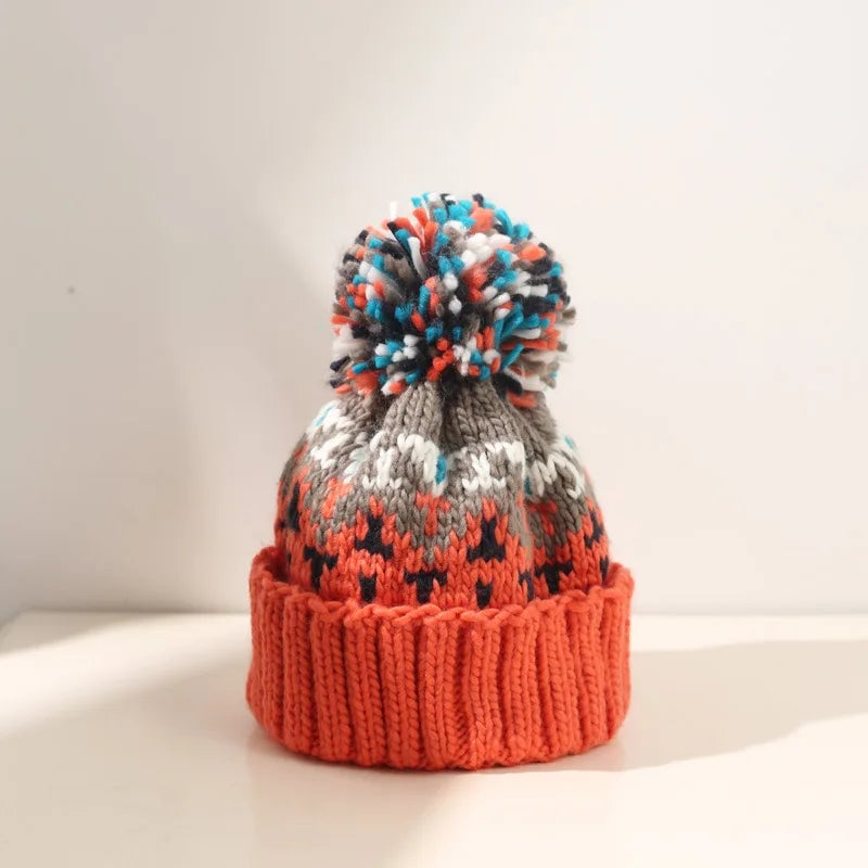 Off-white snowflake pom beanie showing festive knit pattern close-up
