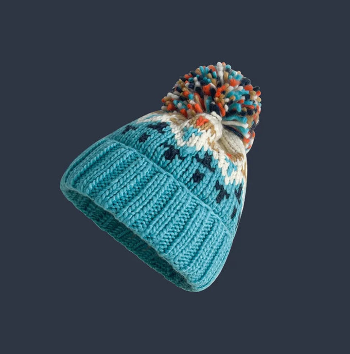 Navy blue snowflake pom beanie styled for a winter outdoor look
