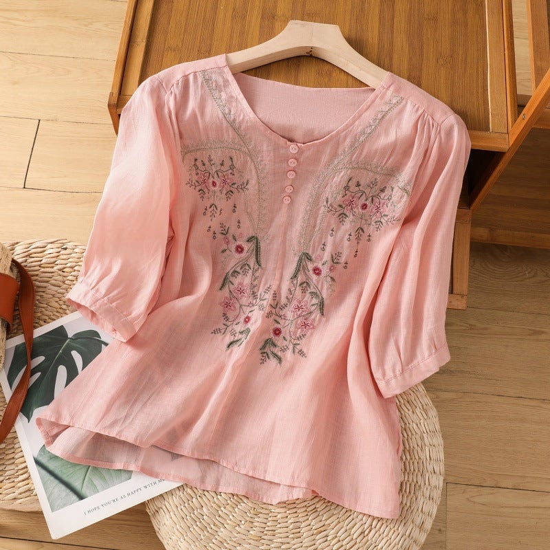 Close-up of delicate floral embroidery detail on relaxed blouse fabric