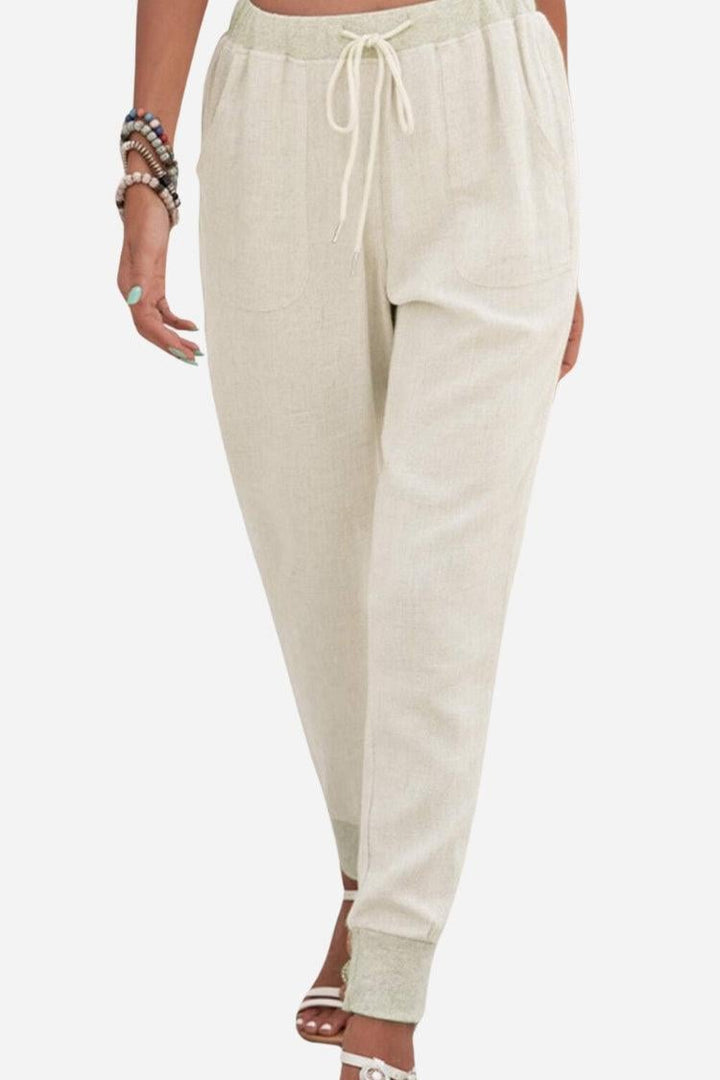Women's beige tapered jogger pants with elastic drawstring waist and ankle cuffs, front view