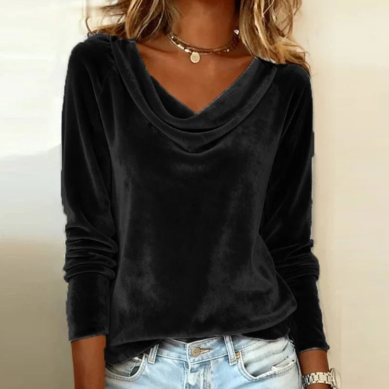 Front view of the blue velvet drape-neck top styled with tailored trousers