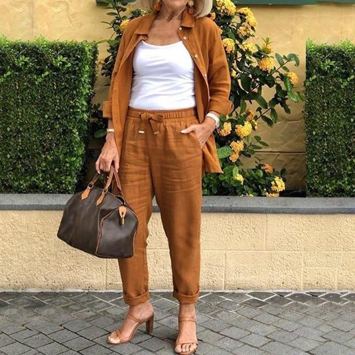 Front view of the Terra two-piece set in brown showing the collared shirt jacket with gold-tone buttons and matching tapered pants
