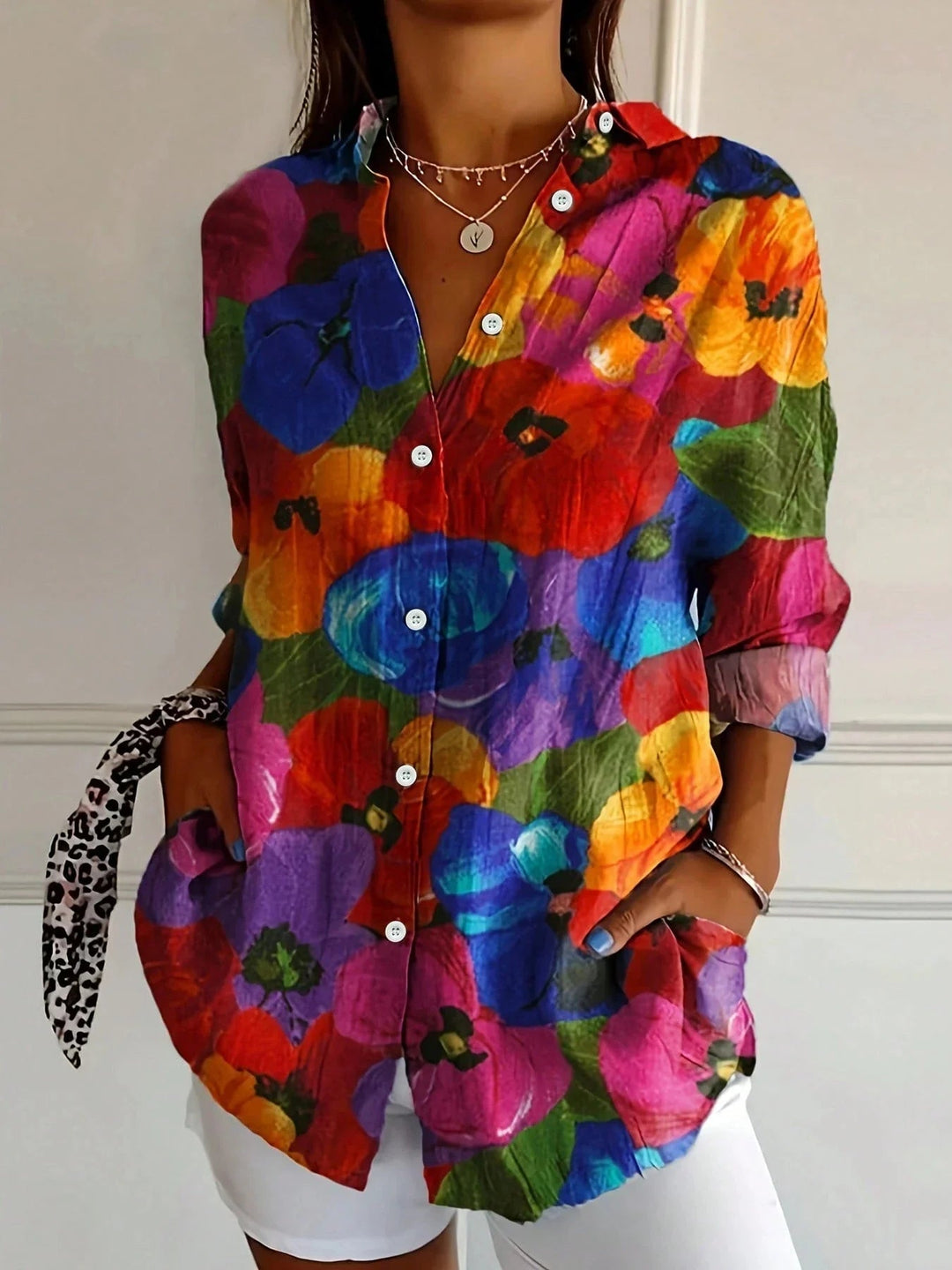 Woman wearing a colorful printed blouse in green colorway, full-length view