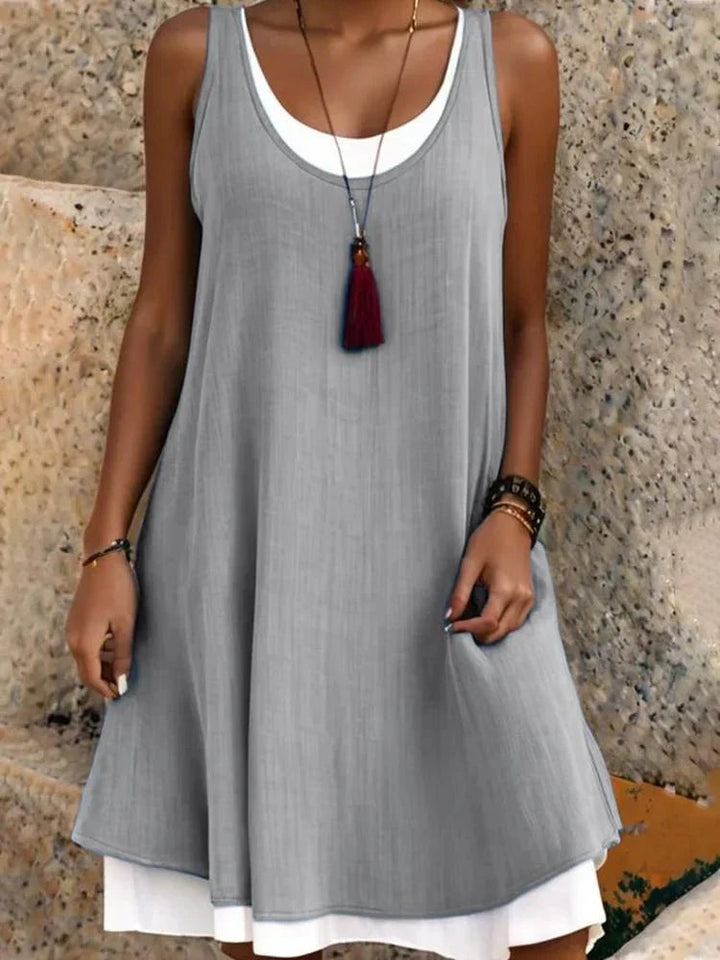 Side view of the Tessa sleeveless mini dress in gray highlighting the scoop neckline and above-the-knee length