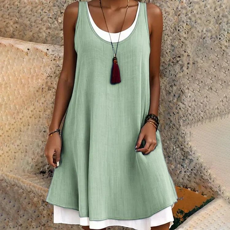 Close-up detail of the Tessa layered mini dress in green showing the contrasting underlayer and flowy outer fabric