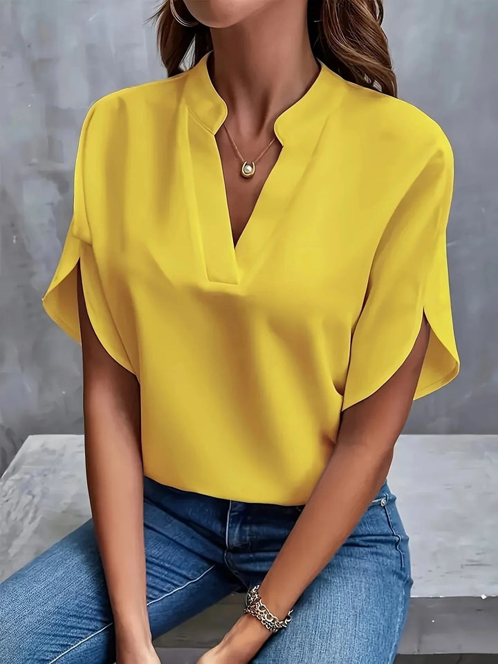 Full-length view of a woman in a sophisticated cap-sleeve blouse paired with tailored trousers for a work-ready outfit