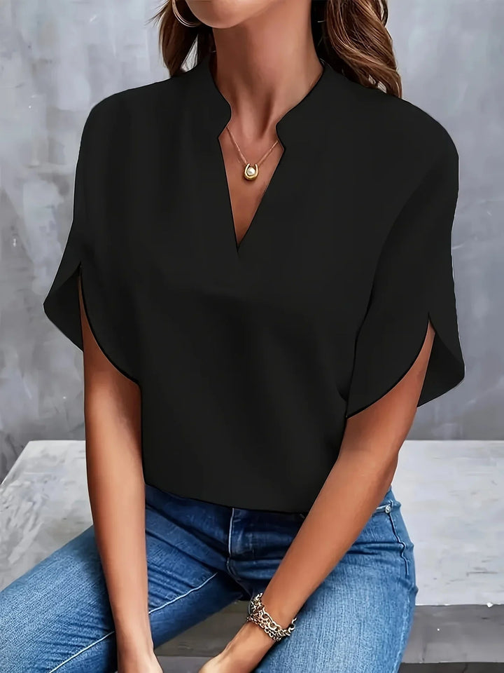 Side profile of a woman wearing a flattering V-neck blouse that flows gracefully at the waist