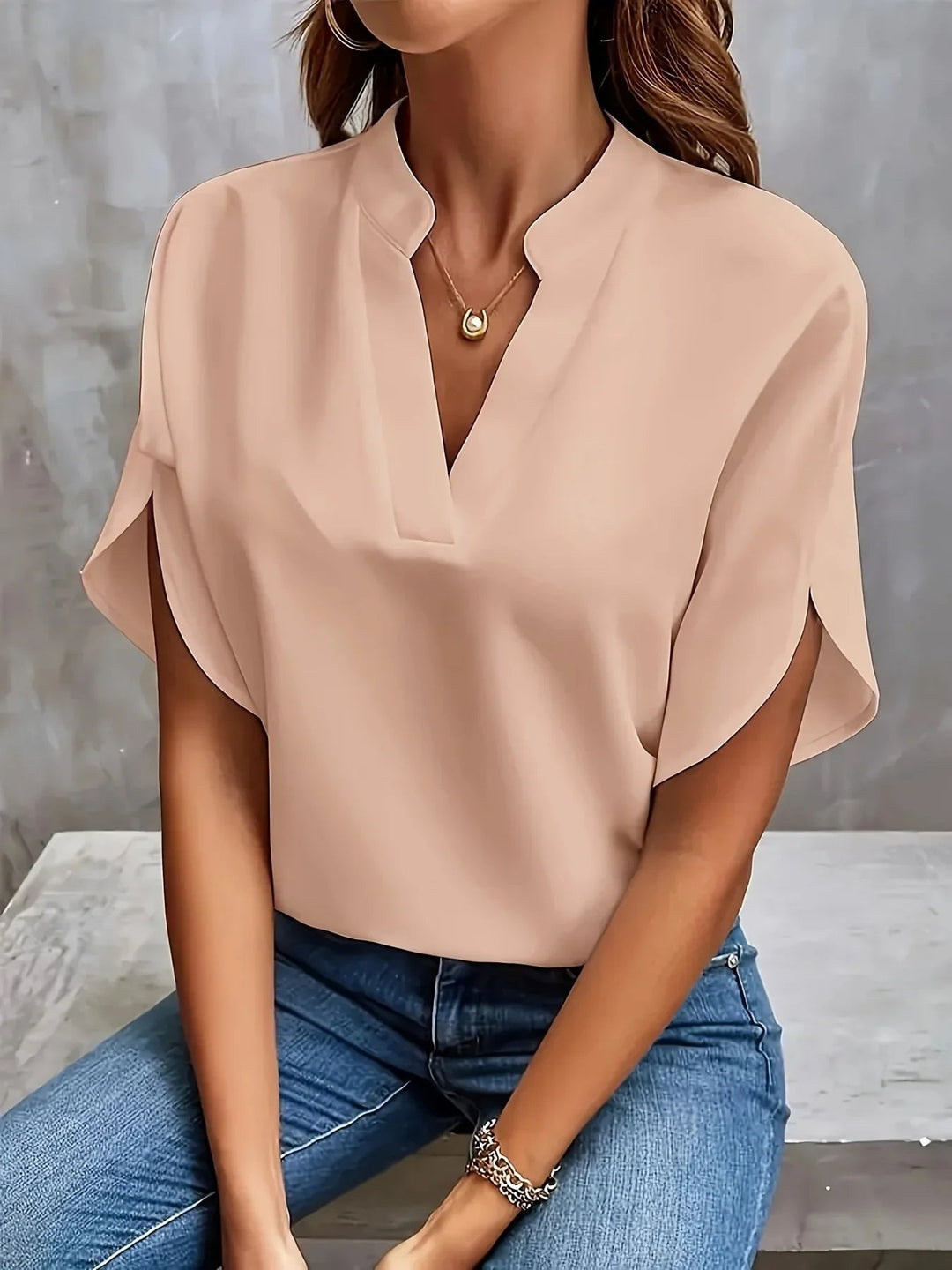 Detail shot of the soft, airy fabric and refined cap sleeve on a versatile tailored blouse
