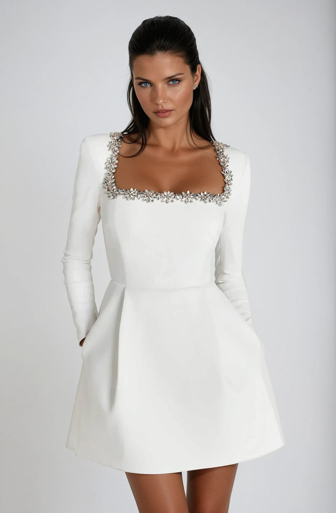 Woman wearing the Theodora mini dress in white, front view, ideal for bridal shower or summer event