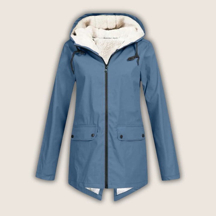 Woman in black ThermaShell rain jacket layered over casual outfit, smiling outdoors