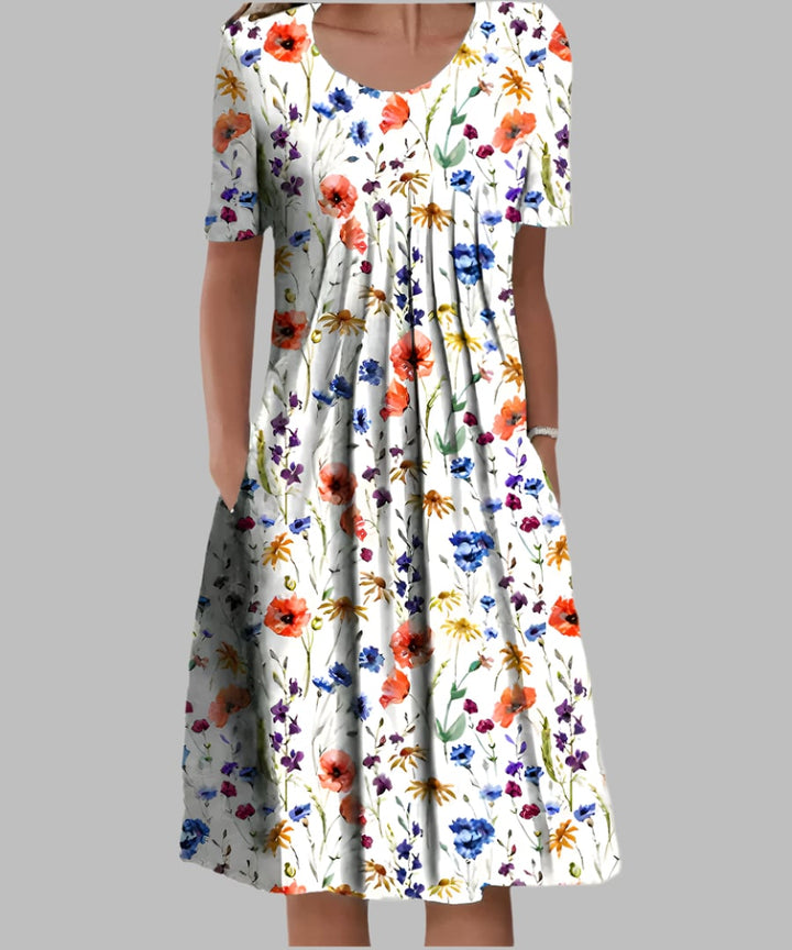 Woman wearing the Tina elegant dress in White and Red floral print, featuring a flowing silhouette and flattering fit