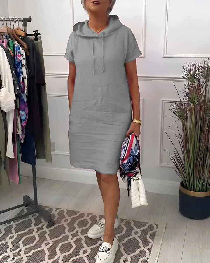 Full-length front view of the relaxed hoodie midi dress in black on a model