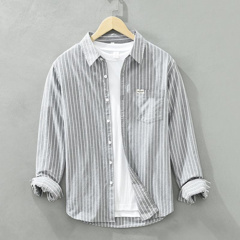 Model wearing a striped casual shirt buttoned up for a smart-casual polished look