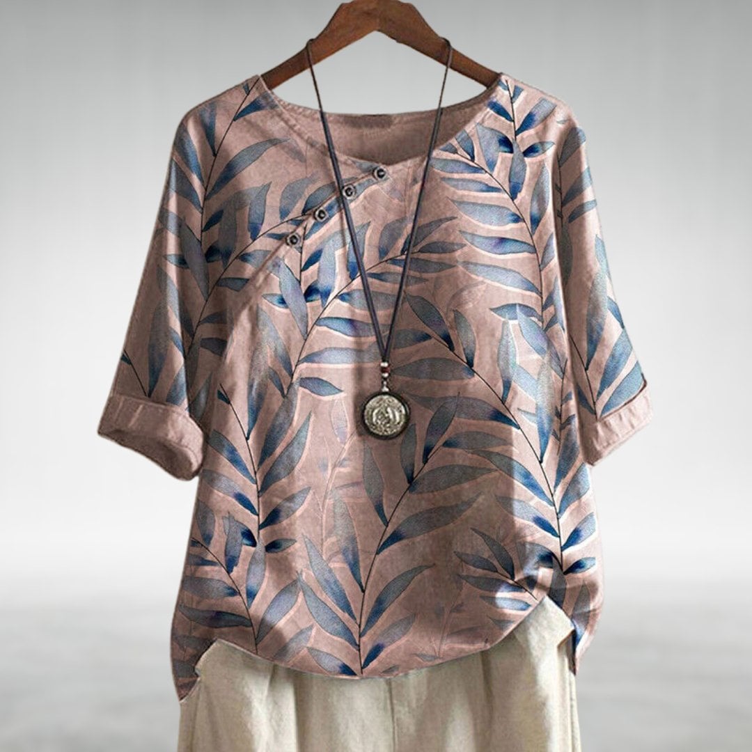 Close-up of the asymmetric button detail on a lightweight flowing women's blouse