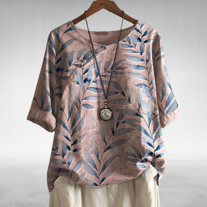 Close-up of the asymmetric button detail on a lightweight flowing women's blouse
